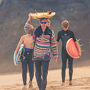 Famille sur la plage en route pour le surf
