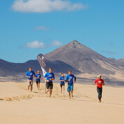 Des élèves surfeurs s’échauffent en trottinant le long de la plage avant leur cours de surf à Fuerteventura.