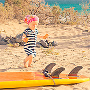 Un petit enfant découvre une planche de surf