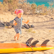 Un petit enfant découvre une planche de surf