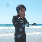 Ton enfant porte un casque de surf recouvert de néoprène – confort et sécurité maximale pendant la session.