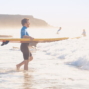 Ton cours de surf à Fuerteventura commence – planche sous le bras, direction les vagues pour vivre ta première aventure en surf.
