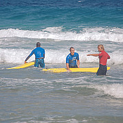 Le moniteur de surf explique la position correcte sur la planche de surf
